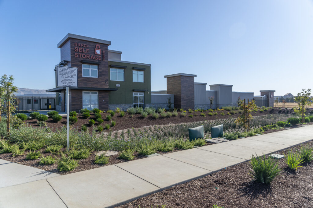 Modern self-storage facility with a landscaped exterior, clear signage, and a bio-retention pond at Gilroy Self Storage Depot